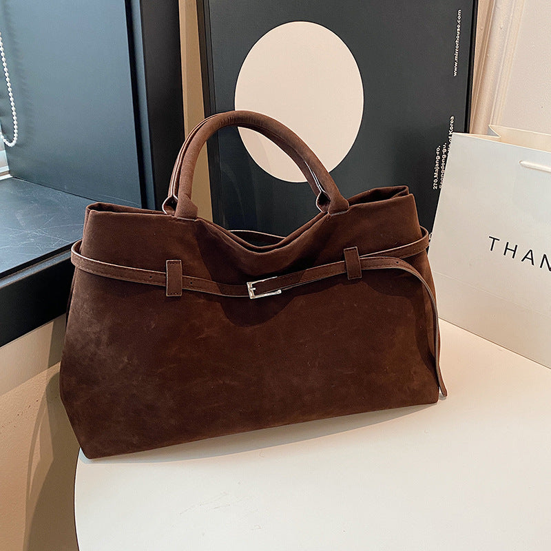 Brown faux suede tote bag styled on a table