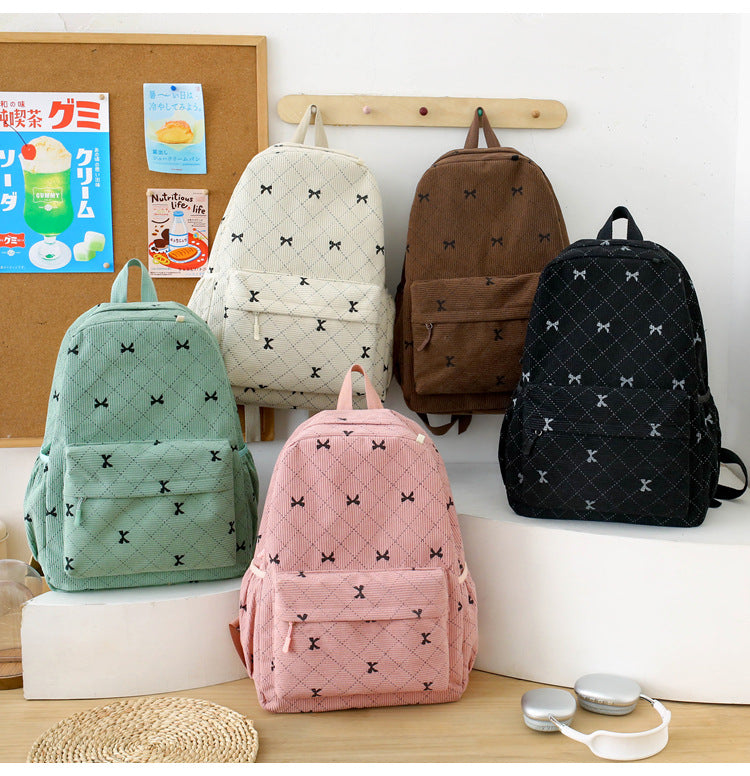 Quilted bow-print backpack shown in mint, ivory, pink, brown, and black